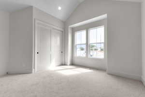 Unfurnished bedroom featuring carpet flooring, vaulted ceiling, recessed lighting, and a closet