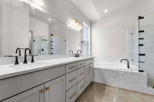Bathroom featuring double vanity, a stall shower, a bath, and recessed lighting