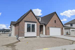 View of front of home with brick siding, driveway, a shingled roof, and a garage