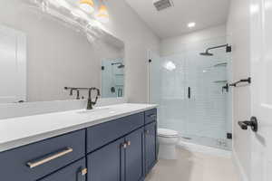 Bathroom featuring vanity, light tile patterned floors, a stall shower, and recessed lighting