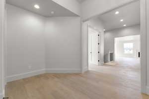 Hallway featuring recessed lighting, light wood-style floors, and an upstairs landing
