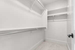 Spacious closet with light colored carpet