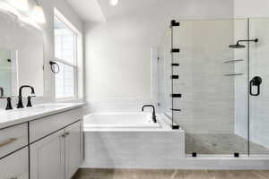 Bathroom with vanity, a garden tub, and a shower stall
