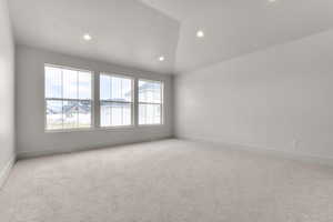 Spare room featuring light colored carpet, lofted ceiling, and recessed lighting