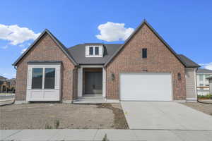 Traditional home with driveway, a garage, brick siding, and roof with shingles