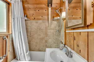 Full bath with shower / tub combo with curtain and a sink