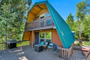 Wooden deck featuring grilling area and a fire pit