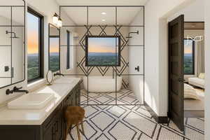 Ensuite bathroom featuring a soaking tub, double vanity, and plenty of natural light