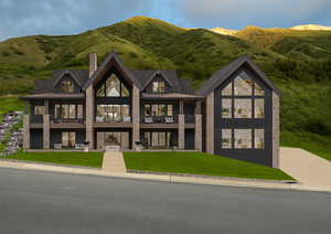 View of front facade with a chimney, a front yard, a balcony, and a mountain view