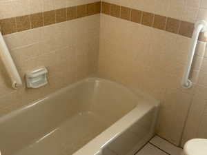 Full bathroom with a tub and tile patterned floors
