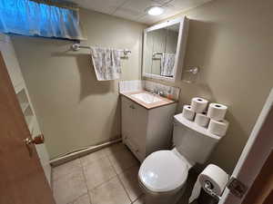 Bathroom featuring vanity, tile patterned flooring, and a paneled ceiling