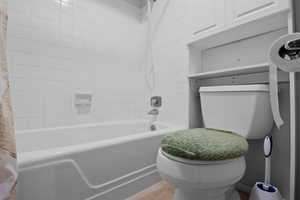 Bathroom with shower / washtub combination and wood finished floors