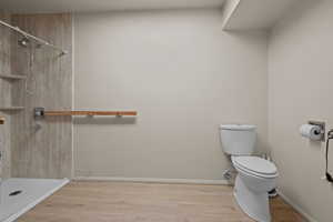 Full bath with a shower and wood finished floors