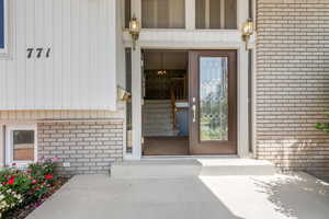 Doorway to property featuring brick siding