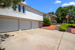 View of front facade featuring driveway, an attached garage, and brick siding