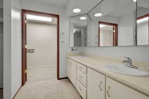 Bathroom with double vanity and baseboards