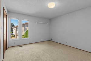 Spare room with a textured ceiling and carpet