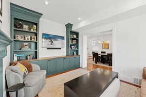 Living room with built in shelves, hardwood floors and recessed lighting