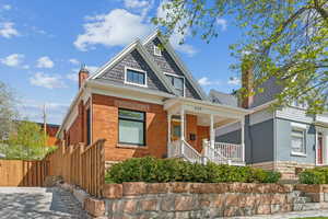 Avenues Victorian home featuring a porch, red brick exterior