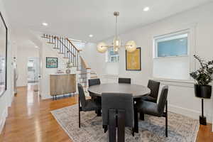 Dining area featuring stairway, oak flooring, a chandelier, and recessed lighting