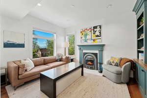 Living area with a lit fireplace, oak hardwood floors, and recessed lighting
