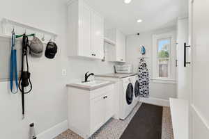 Laundry room with washer and dryer, cabinet space, and recessed lighting