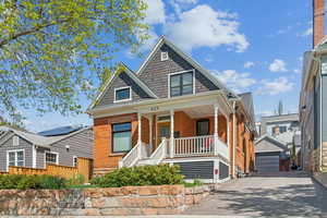 Avenues Victorian home with covered porch, a garage, and red brick exterior
