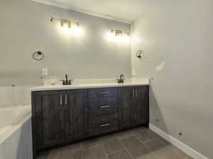 Bathroom featuring double vanity, a bath, and tile patterned flooring