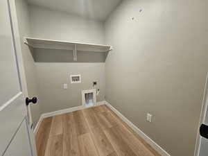 Laundry room with hookup for an electric dryer, light wood-style floors, and hookup for a washing machine