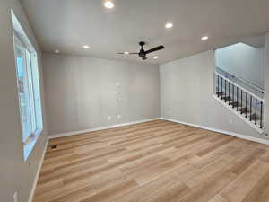 Empty room with light wood-type flooring, recessed lighting, ceiling fan, and stairs