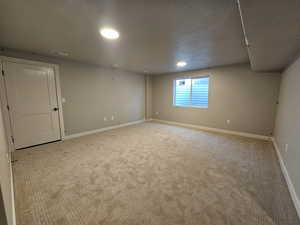 Spare room with light carpet and a textured ceiling