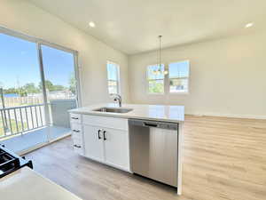 Kitchen featuring dishwasher, light wood finished floors, a chandelier, plenty of natural light, and recessed lighting