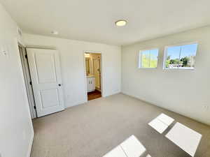 Unfurnished bedroom featuring carpet and connected bathroom