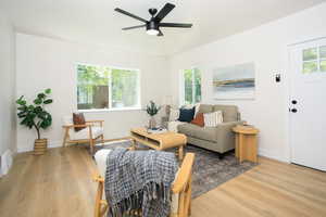 Living room with light wood-style flooring and a ceiling fan