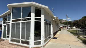 View of side of property with a sunroom