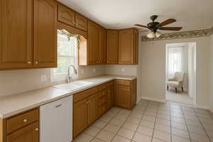 Digitally Staged: Kitchen with dishwasher, light countertops, a ceiling fan, and brown cabinetry