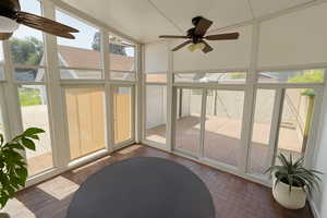 Digitally Staged: Sunroom featuring a ceiling fan and lofted ceiling