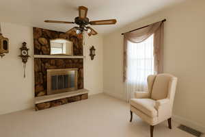 Digitally Staged: Living room with ceiling fan, a stone fireplace, and carpet floors