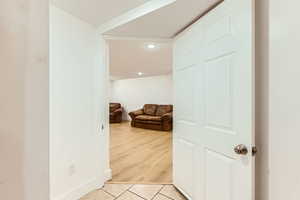 Hall featuring light tile patterned floors and recessed lighting