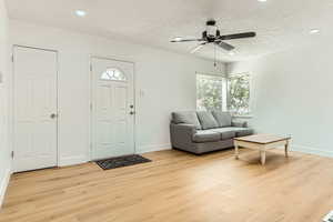Entrance foyer with light wood-style floors, healthy amount of natural light, ceiling fan, a textured ceiling, and recessed lighting