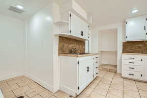 Kitchen with open shelves, backsplash, light tile patterned flooring, light countertops, and recessed lighting