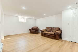 Sitting room with light wood-style flooring, recessed lighting, and baseboard heating