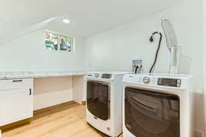 Laundry room featuring cabinet space, light wood-style flooring, washing machine and clothes dryer, recessed lighting, and a desk