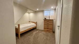 Carpeted bedroom featuring a textured wall and recessed lighting