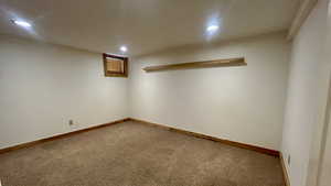 Finished basement with carpet flooring and recessed lighting