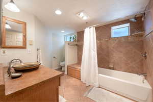 Full bathroom with plenty of natural light, vanity, shower / tub combo, tile patterned floors, and recessed lighting
