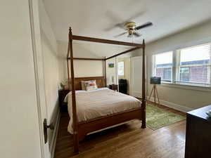 Bedroom with wood finished floors, ceiling fan, and beamed ceiling