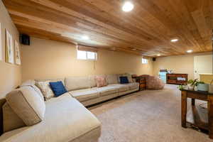 Carpeted living room featuring wooden ceiling and recessed lighting