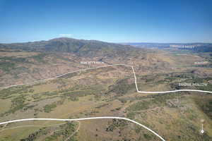 Aerial overview of property's location featuring property parcel outlined and a mountain backdrop