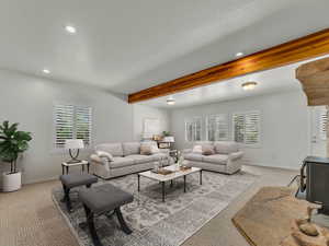 Living room with a wood stove, recessed lighting, and beam ceiling